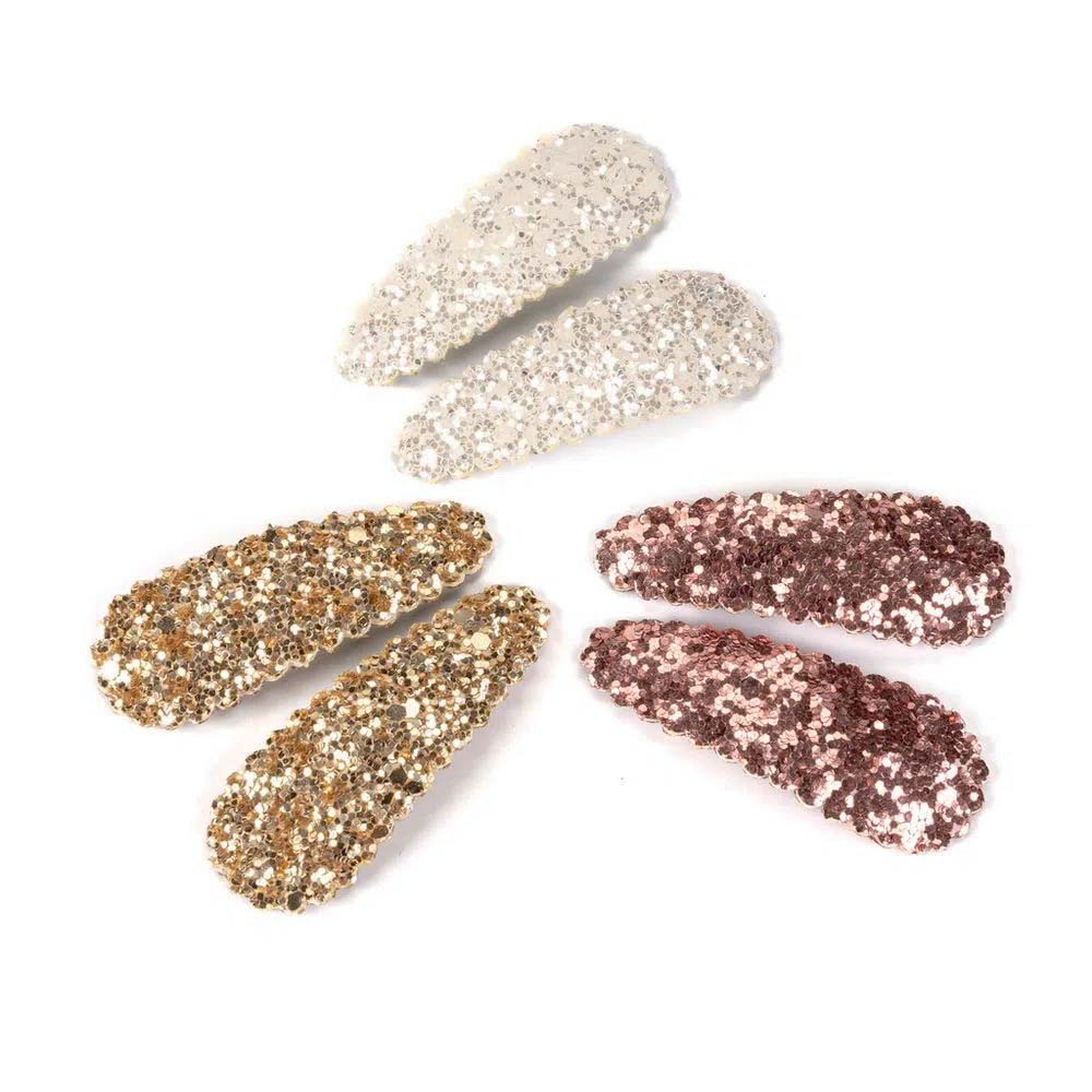 Tr&ecirc;s pares de presilhas com glitter, cada um de uma cor: um dourado, um prata e um ros&ecirc;