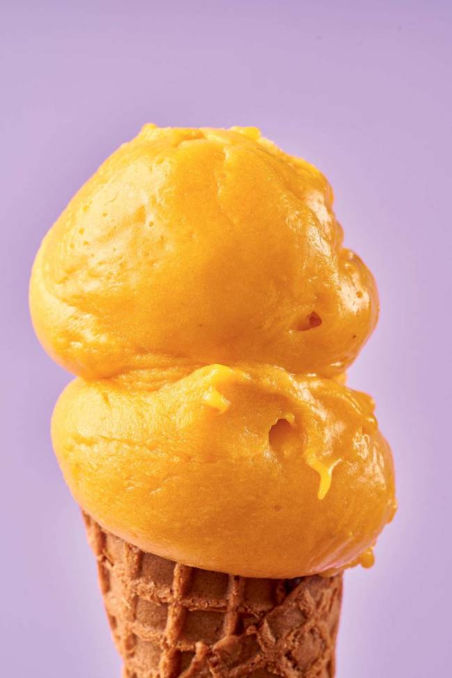 Close em duas bolas de sorvete amarelo sobre casquinha