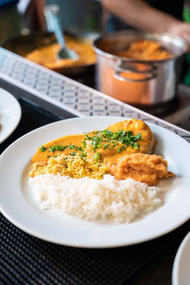 Prato com moqueca de peixe, arroz, farofa e pirão de cachaça