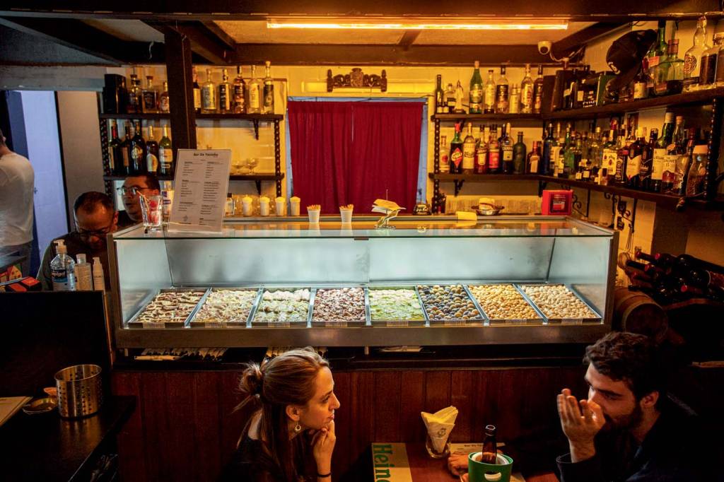 Imagem mostra interior de bar com vitrine mostrando petiscos à venda