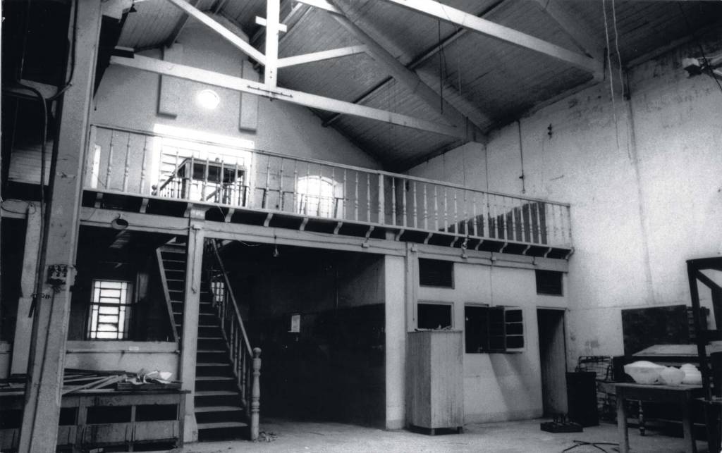 Foto em preto e branco de antiga fábrica de carimbos.