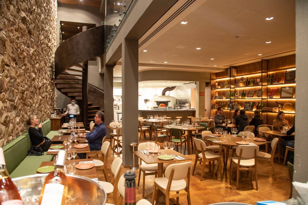 Ambiente de restaurante com mesas e nos fundos uma escada caracol