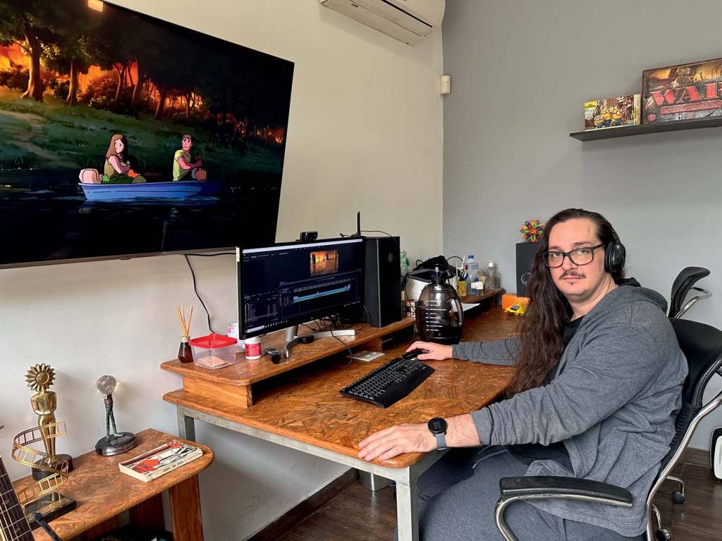 Split Studio Imagem mostra homem sentado em cadeira, mexendo no computador
