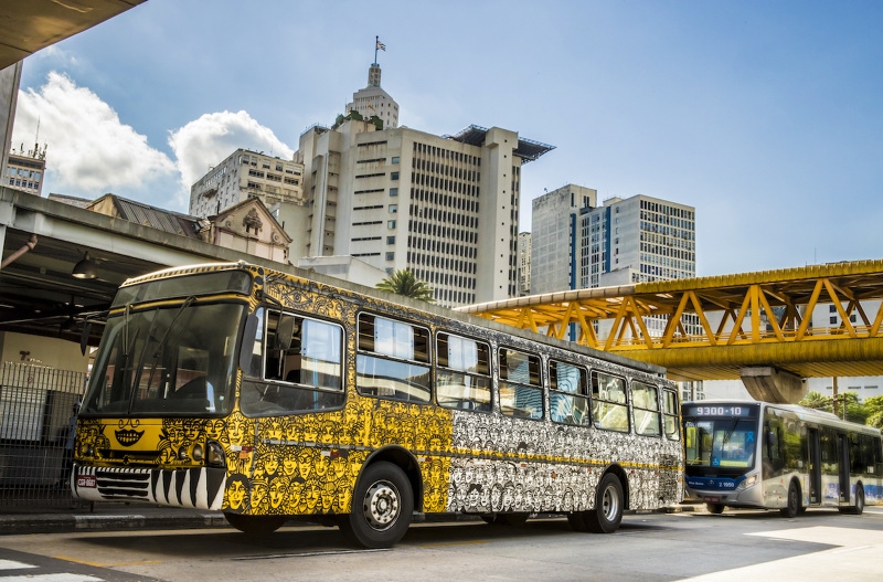 Imagem mostra ônibus customizado, com adesivo amarelo e branco