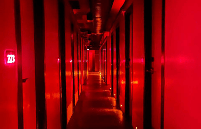 Imagem mostra corredor iluminado por luz vermelha