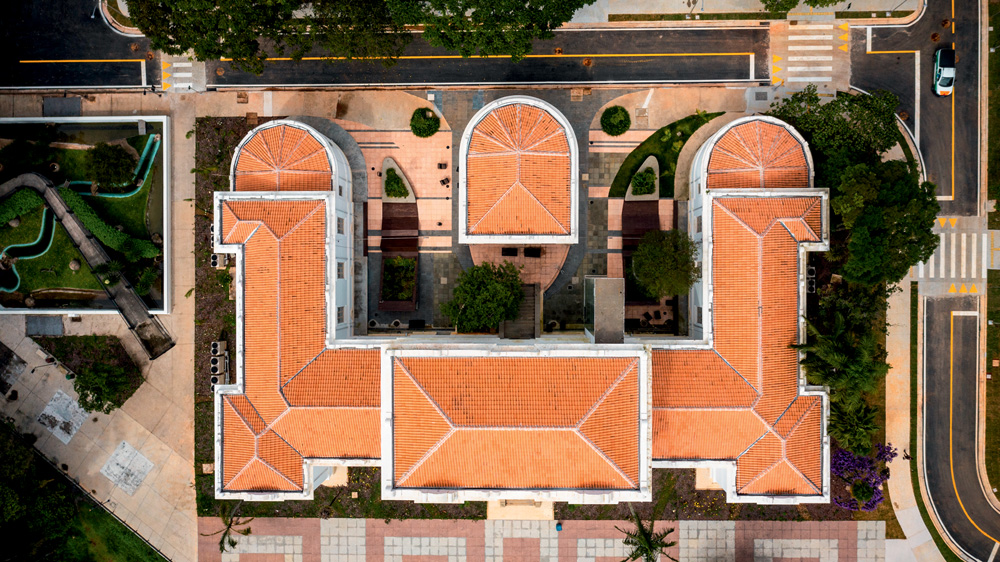 Vista aérea do Edifício Vital Brazil, com paredes brancas, jardim na frente e telhado marrom.