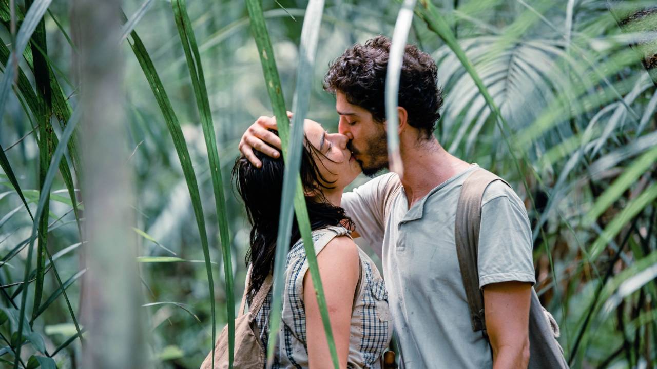 Casal se beija no meio da floresta