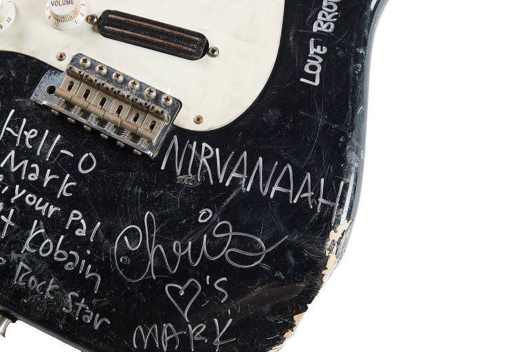 Parte de guitarra preta e branca com assinaturas de integrantes da banda Nirvana.