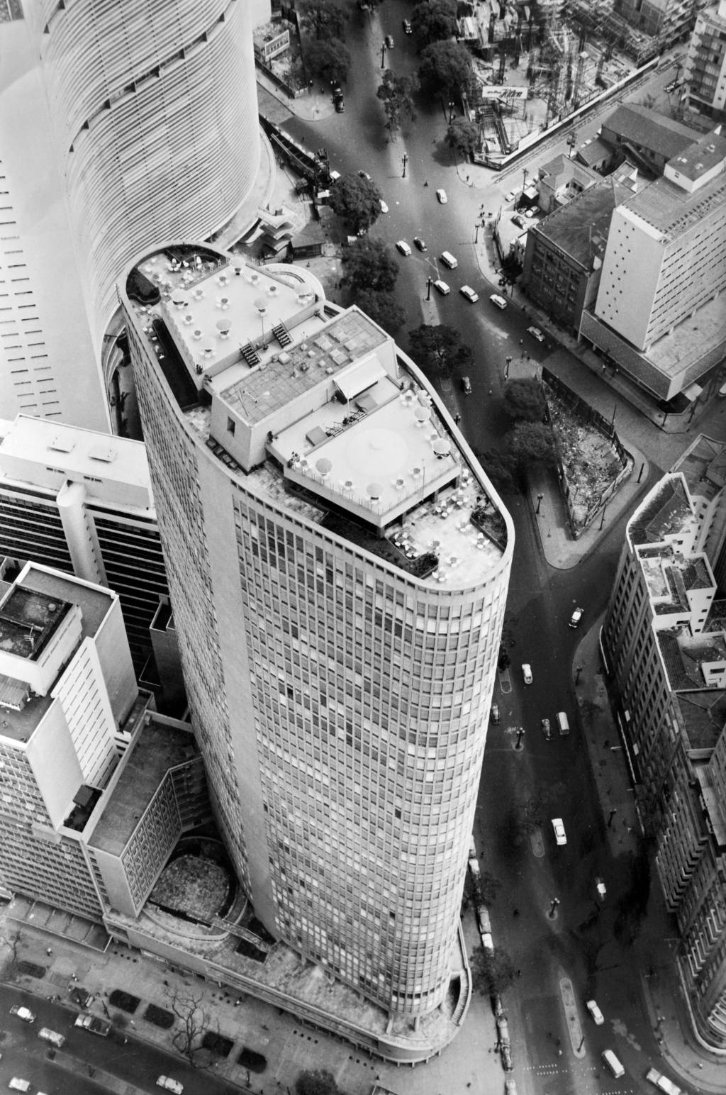 Foto aérea em preto e branco exibe topo de edifício alto.