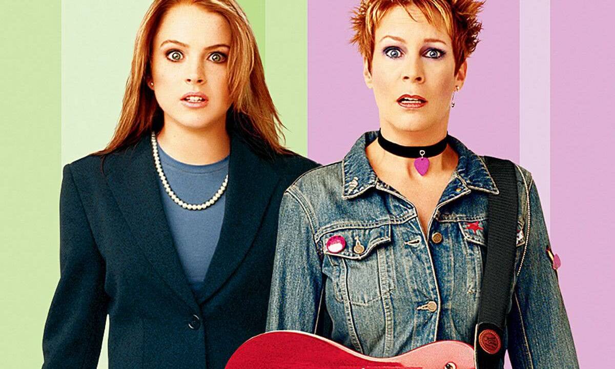 Duas mulheres com caras espantadas, uma de roupa de trabalho e a outra com roupa de rockeira