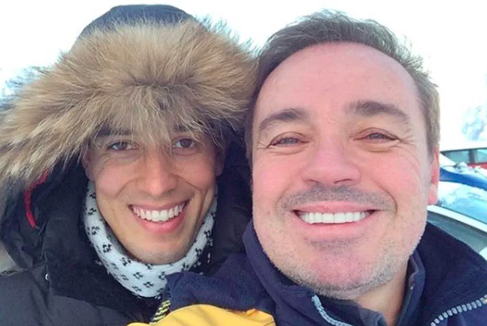 dois homens brancos com roupas de frio pousando para uma selfie