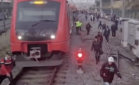 um trem parado e pessoas andando pelos trilhos