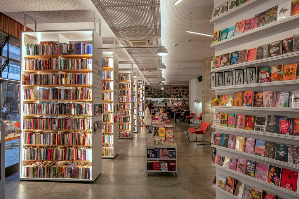Foto de ambiente de livraria com prateleiras brancas e iluminadas.