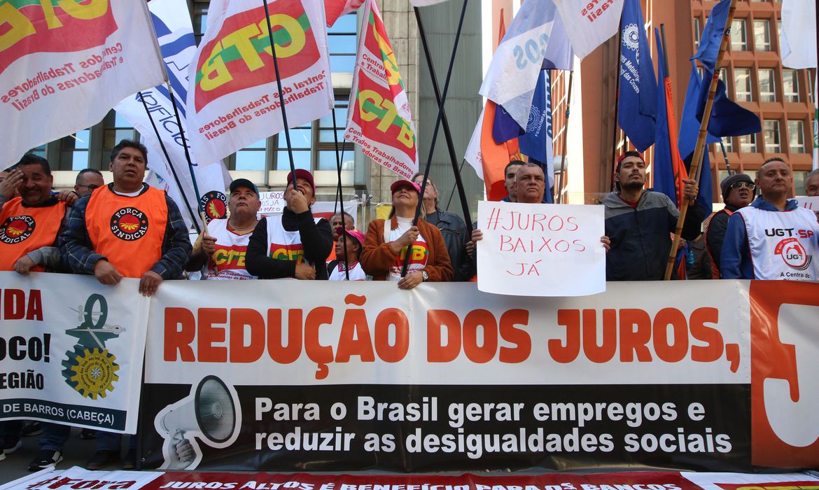 pessoas se manifestando com cartazes e bandeiras