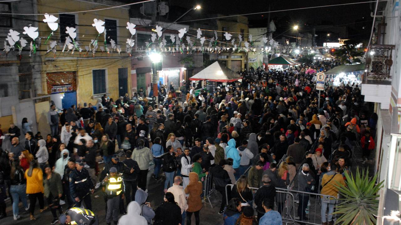 Festa de rua com bandeirinhas atravessando de um lado pro outro.