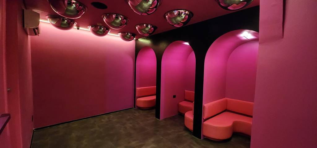 Espaço rosa com três cabines e sofás rosa