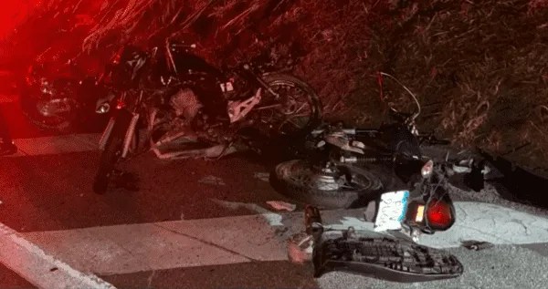 Imagem mostra três motos caídas e quebradas na lateral de pista de rodovia durante a noite