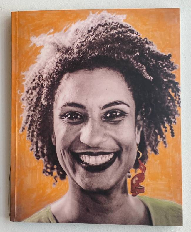 a capa do livro mostra marielle franco, uma mulher negra, de cabelos soltos, sorrindo