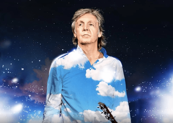 Paul McCartney com uma galáxia atrás e nuvens em sua camisa