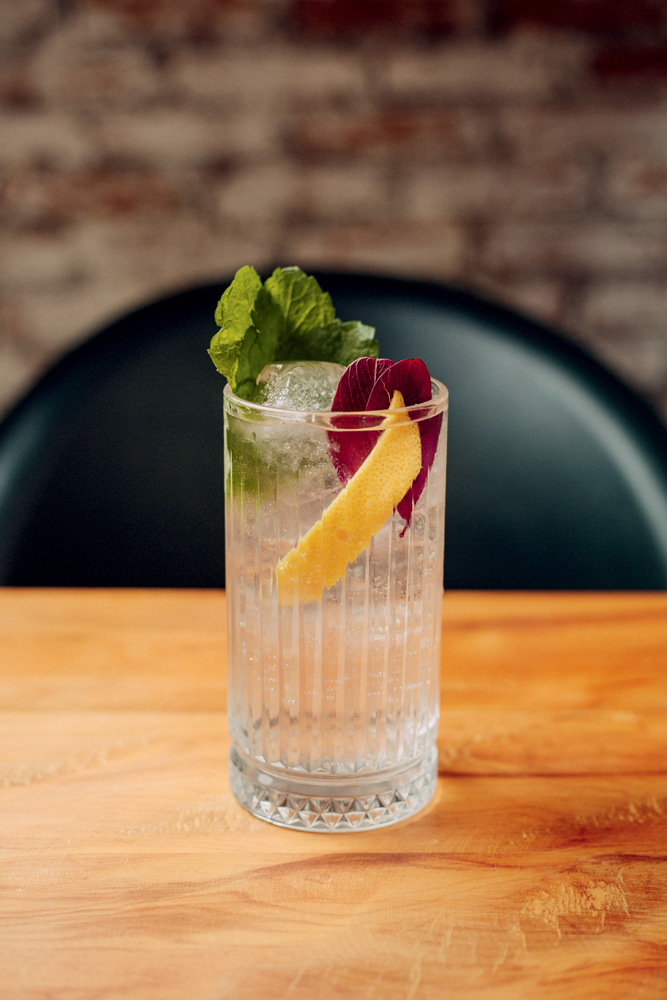 Dia dos Pais – Atto Drink transparente em copo alto sobre mesa de madeira.