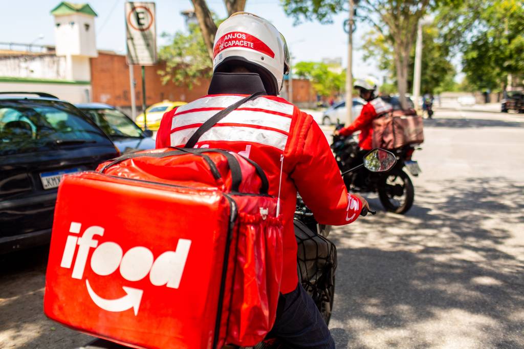 Entregador em moto com a mochila vermelha do iFood.