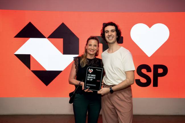 Imagem mostra homem e mulher segurando placa da Vivo em premiação