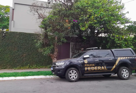 carro da polícia federal em frente a uma casa