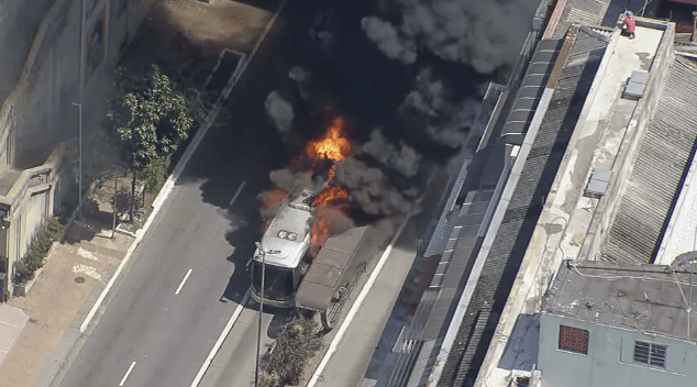 um ônibus em chamas com muita fumaça em cima dele