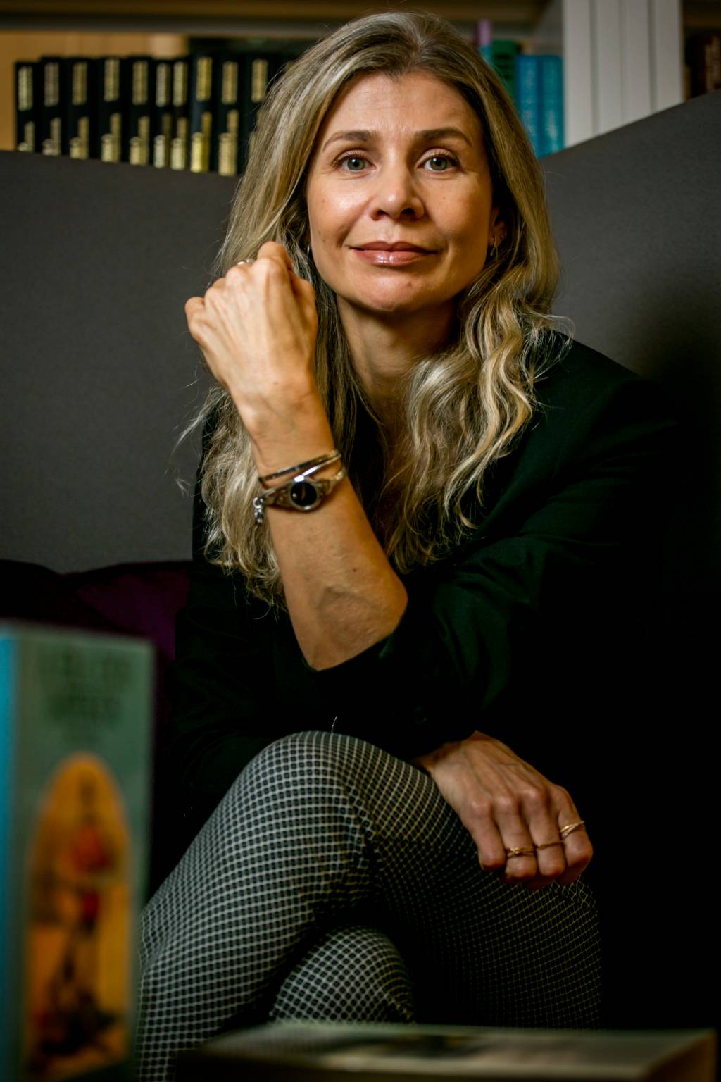 Milena Seabra, Faculdade Belavista (Léo Pinheiro-Divulgação) (4) Mulher loira dá meio sorriso sentada com os cotovelos apoiados na perna cruzada. Veste jeans e suéter preto.