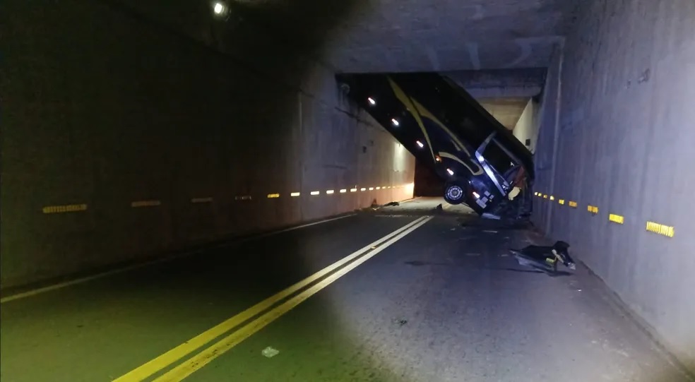 Ônibus caído em vão aparece inclinado em avenida escura