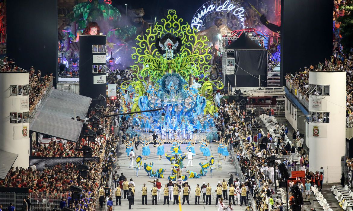 a imagem mostra o carro abre-alas da escola de samba pérola negra com diversos bailarinos a frente