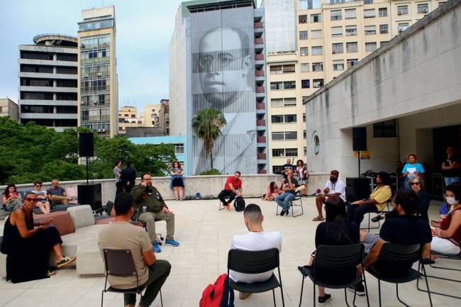 Roda de conversa no terraço da Biblioteca Mário de Andrade, na edição de 2022 do festival. Ao fundo, fachada da hemeroteca com rosto do poeta
