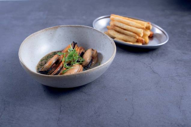 Mexilhões ao molho de caldos de frango e do marisco com feijão preto fermentado e creme de leite: servido com fritas