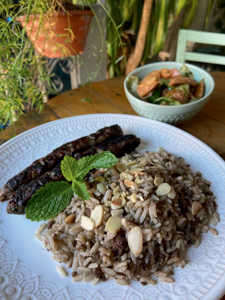 Circuito Comer & Beber – Chef Benon Prato de louça branca com arroz ao lado de duas caftas