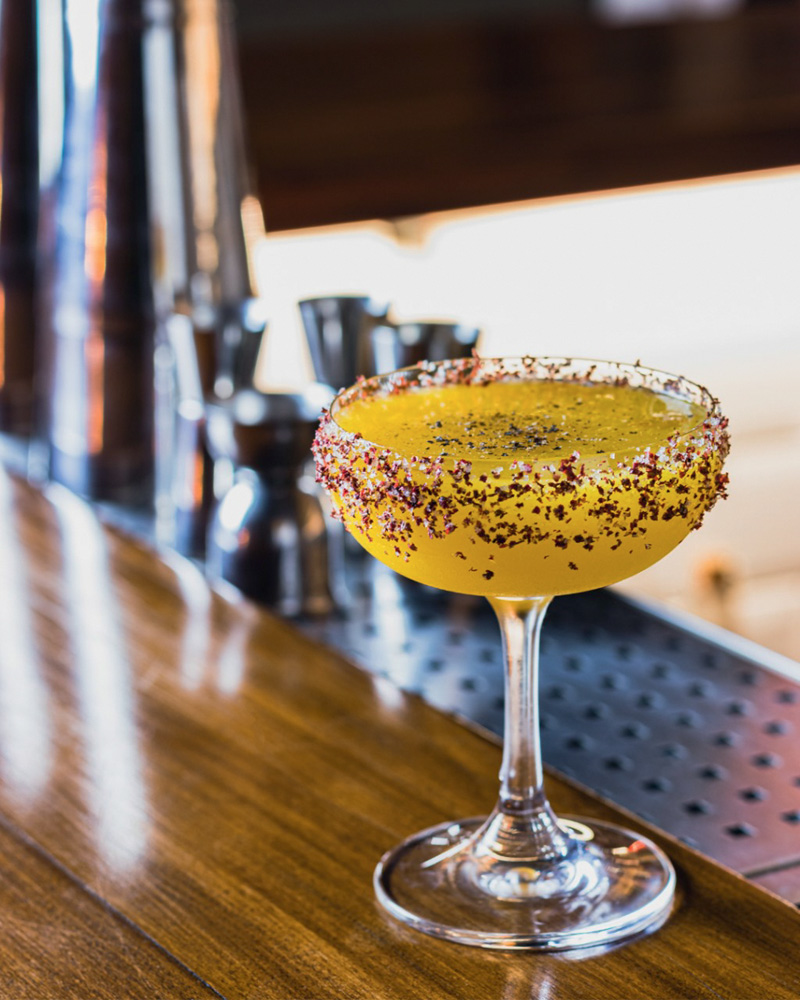 Circuito Comer & Beber – Trago Bar Drinque amarelo em taça coberta por pimenta rosa moída por fora