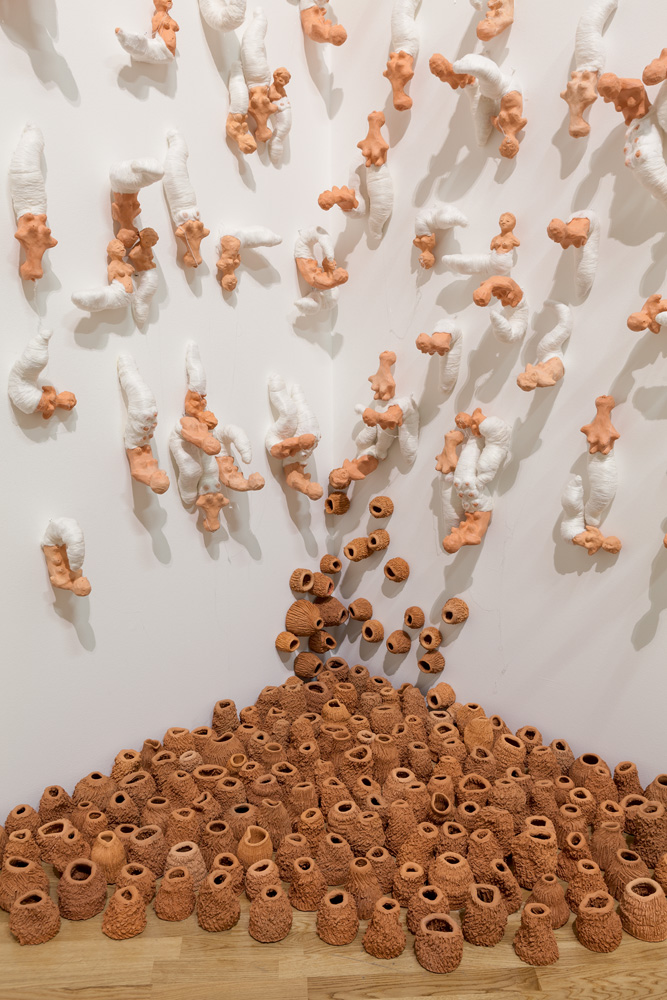 Rosana Paulino, Tecelãs instalação, 2003-Crédito Rosana Paulino-Divulgação Peças de barro em parede branca e amontoadas no chão