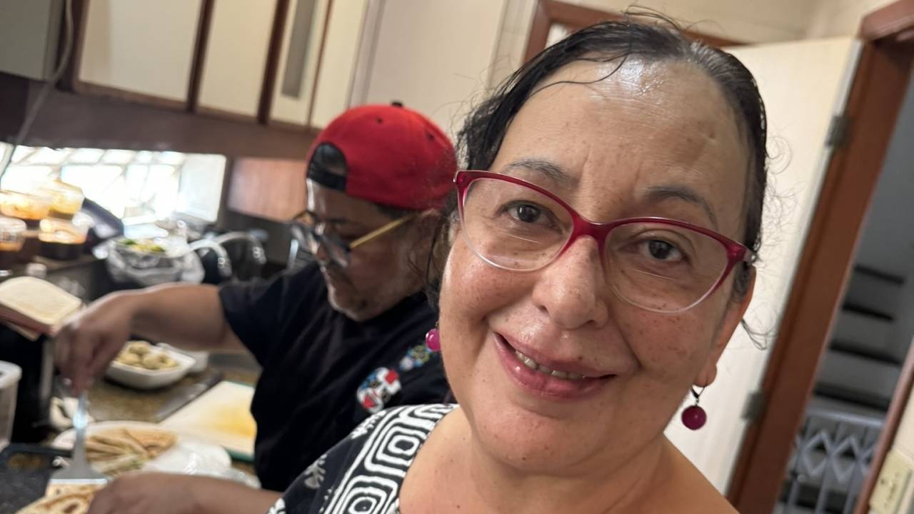 A cozinheira Lourdes Hernández trabalhando em uma cozinha com outro profissional ao fundo