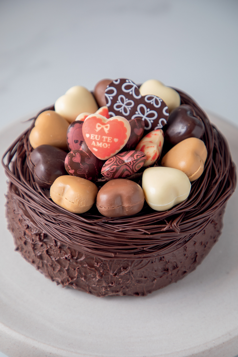cestinha de chocolate cheia e corações de chocolate de diferentes cores