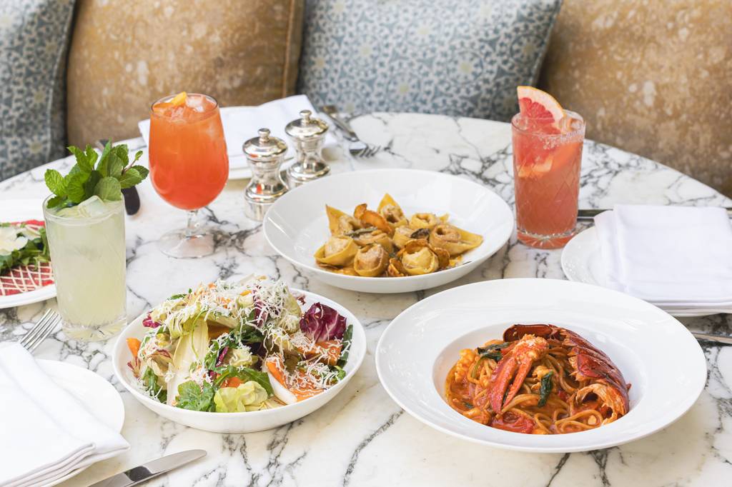 Cecconi’s Três pratos de comida italiana e drinks alaranjados na mesa