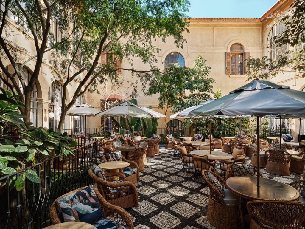 Soho House Sao Paulo, courtyard 1 – Credit_ Christopher Sturman Ombrelones, mesas e árvores em pátio central