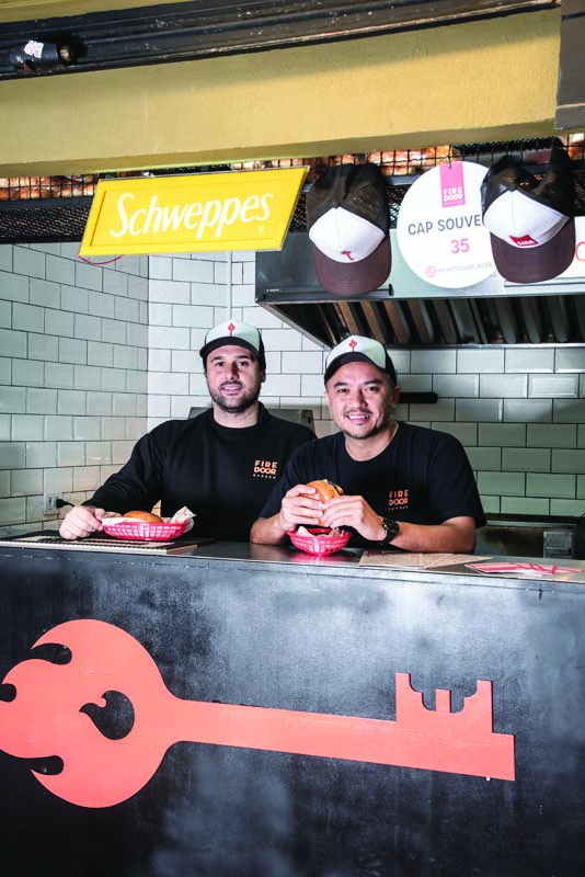 Dois homens dentro da cozinha da lanchonete