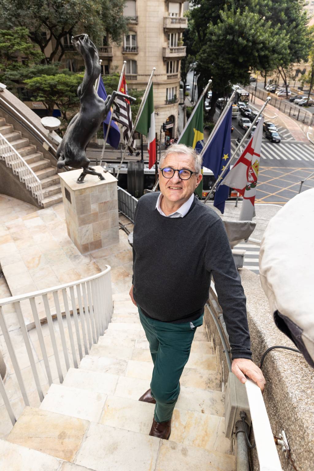 José Messina, Circolo Italiano Crédito Leo Martins-VejaSP (5) Senhor de óculos e grisalho posa em escadaria com bandeiras e escultura de cavalo atrás