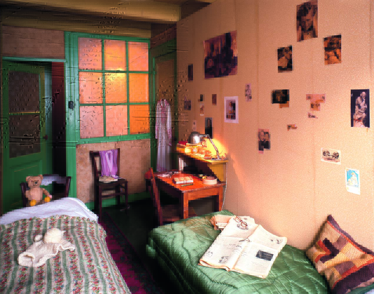 Foto de quarto com cama verde, porta verde com vidros, outra cama à esquerda e fotos na parede branca
