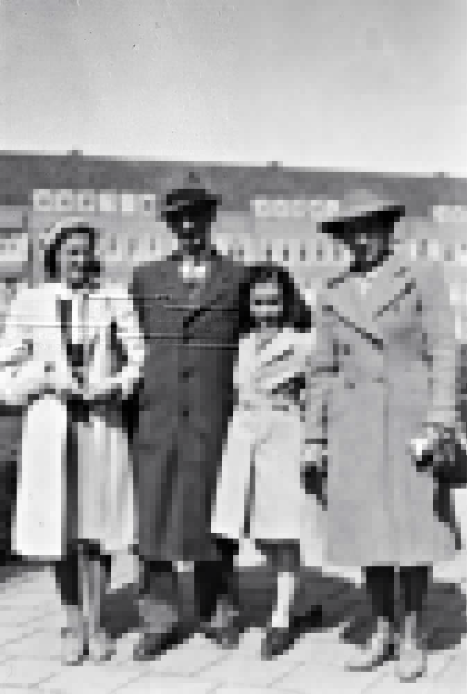 Foto em preto e branco de garota com três adultos em praça