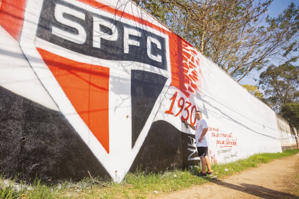 Alan Salles Allan, em frente ao mural que está sendo pintado