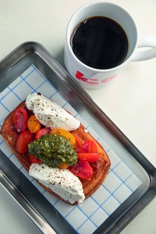 Folhado caprese e caneca com café em cima de bandeja