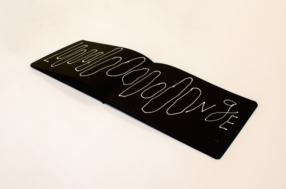 Poema Longe: feito em caderno com tinta branca e transformado em LED para a mostra