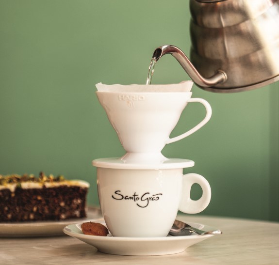 Café sendo coado na xícara com fundo verde