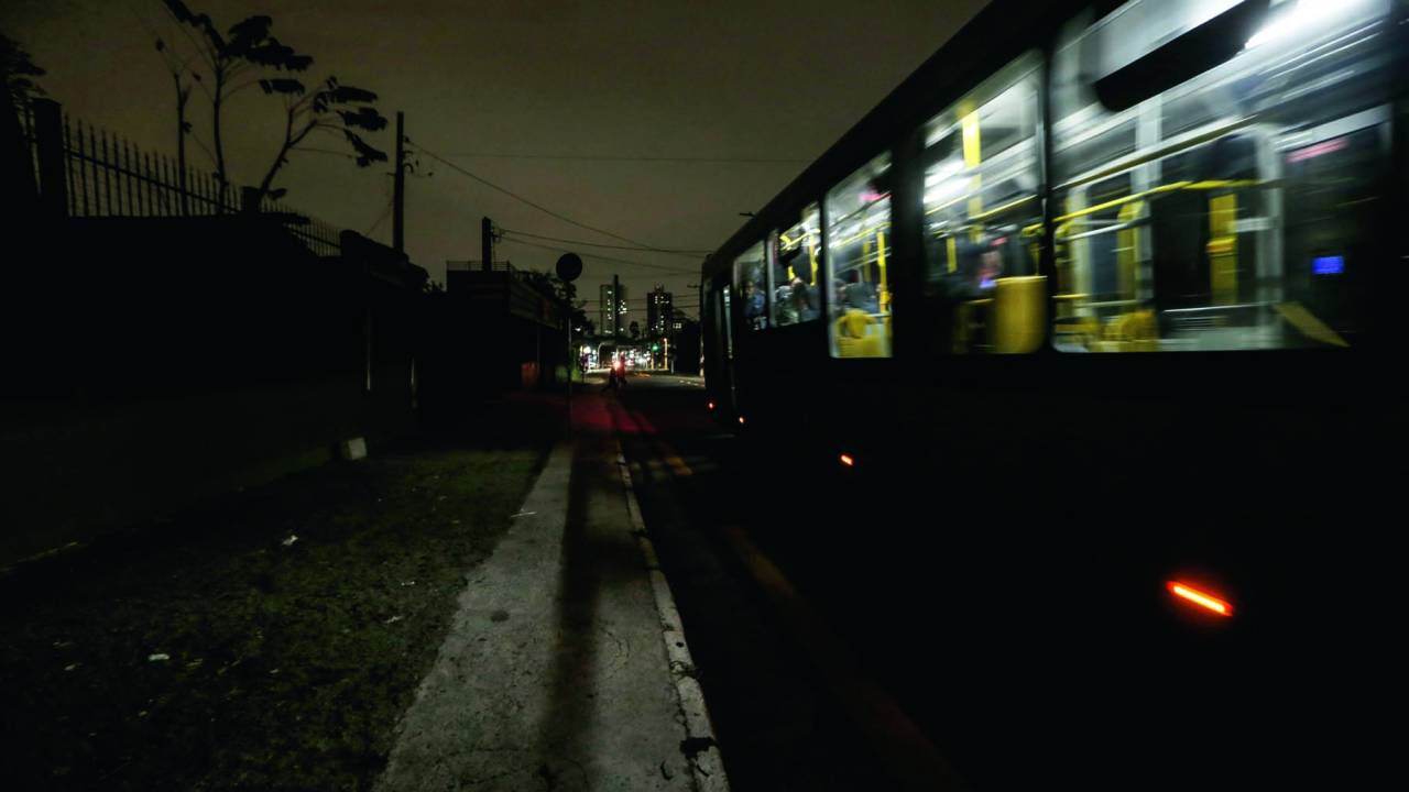 Ônibus passando na rua sem luz