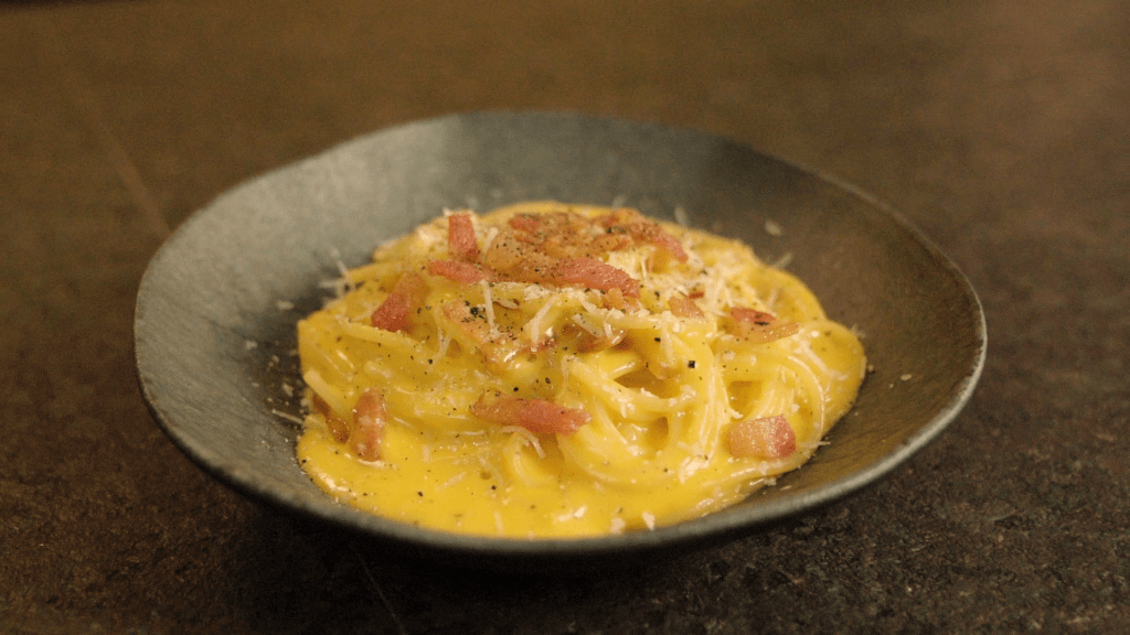 Prato cinza com espaguete à carbonara do chef Antonio Maiolica